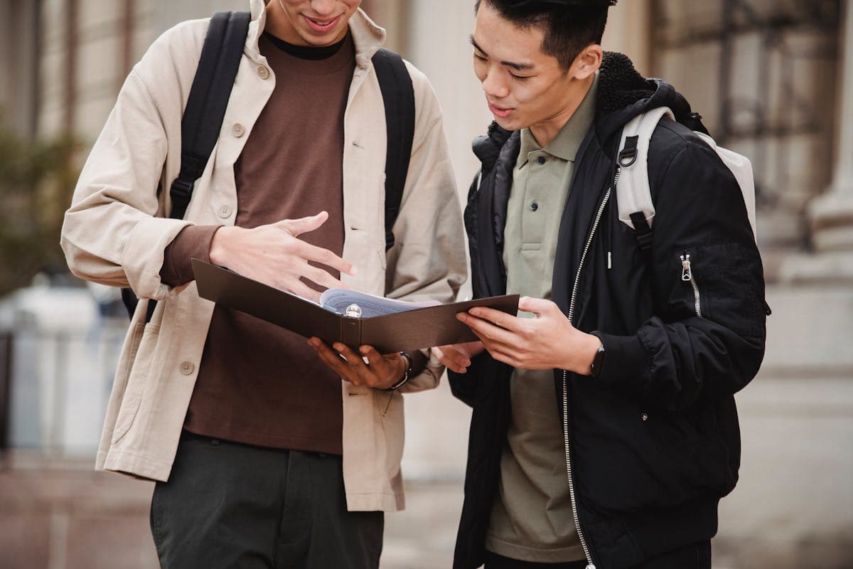 Students sharing documents near a university