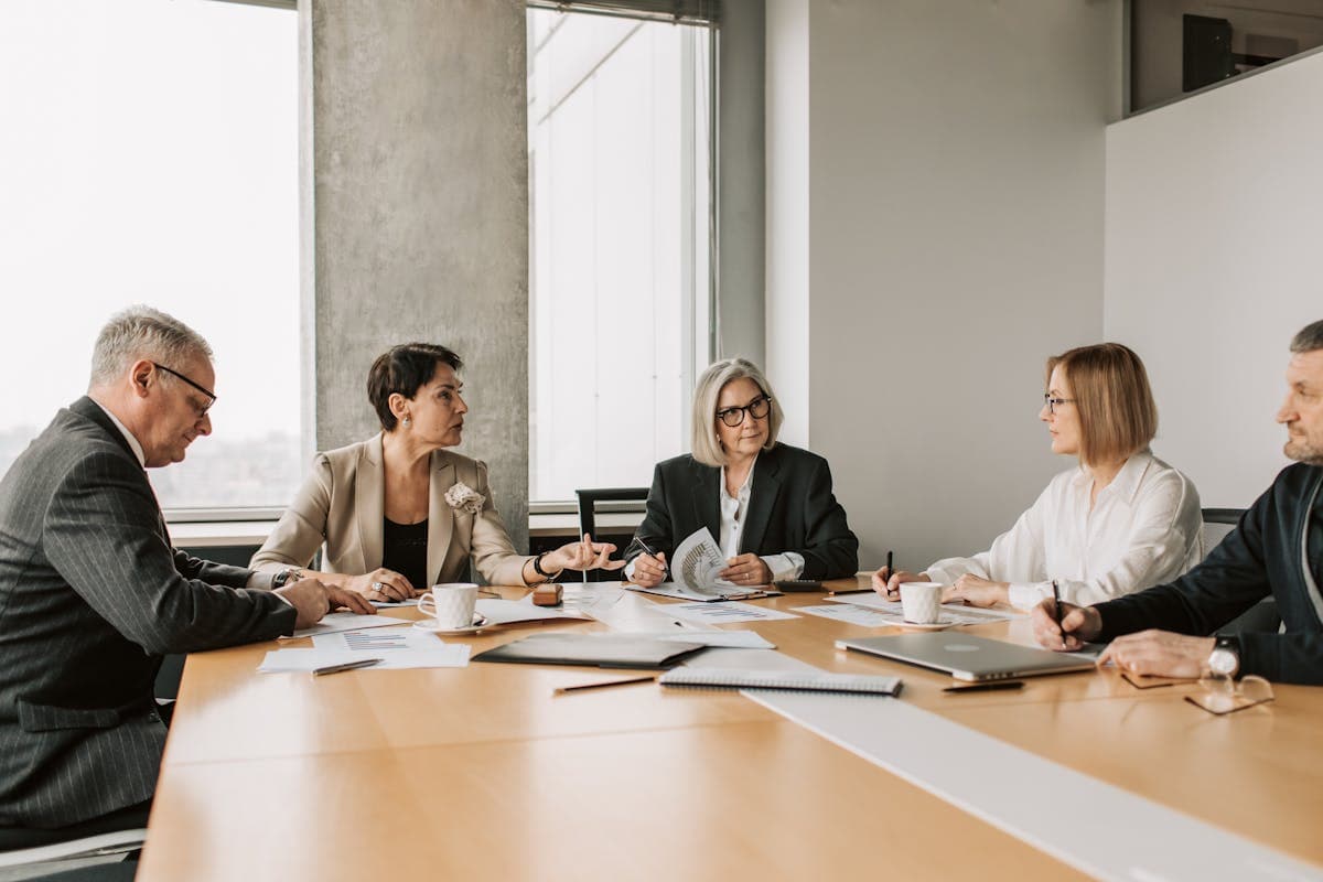 Professionals discussing documents in a modern boardroom